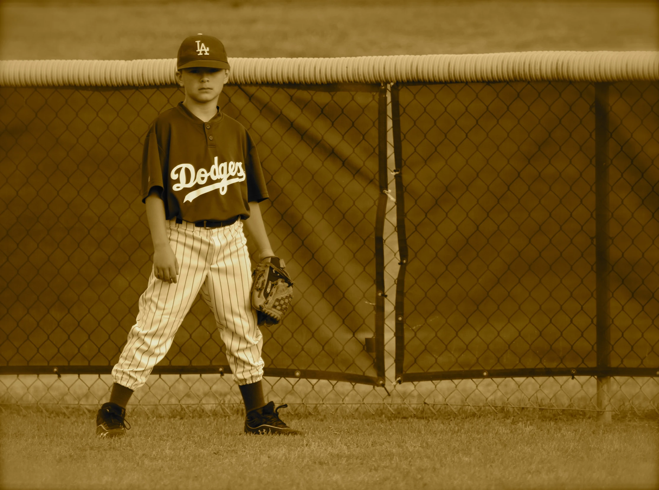 a  stands in a baseball uniform with his glove