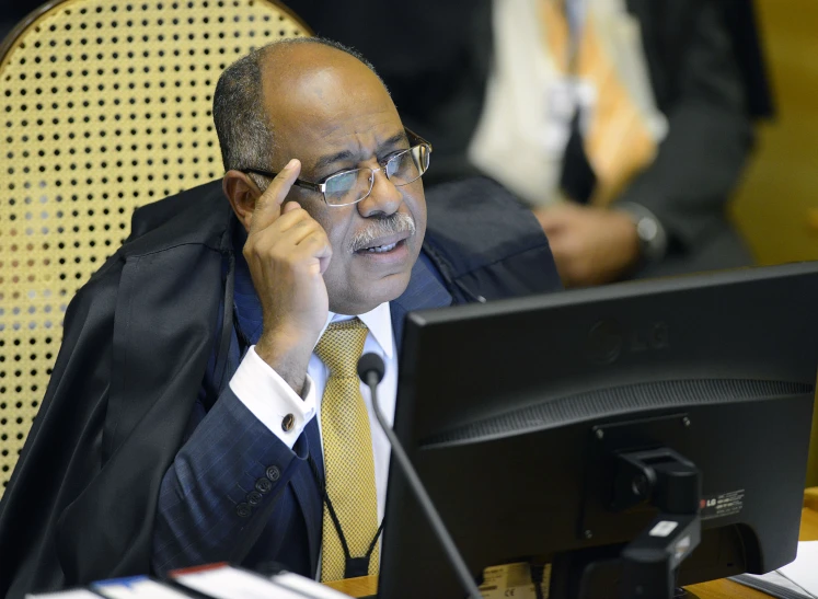 a man in glasses and a suit talking on a phone