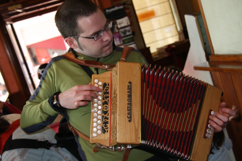 a man in a green shirt holding an open accordion