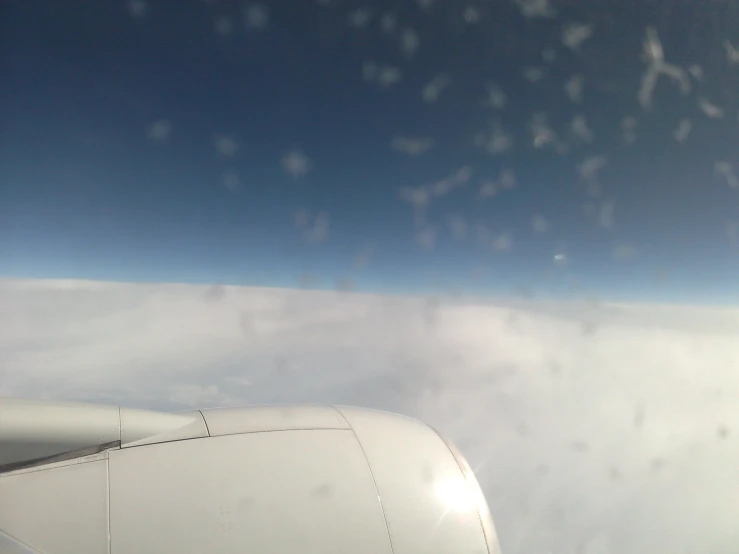 the view from an airplane window with white clouds below it