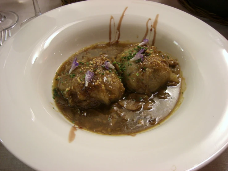 there is a plate with meatballs in a gravy