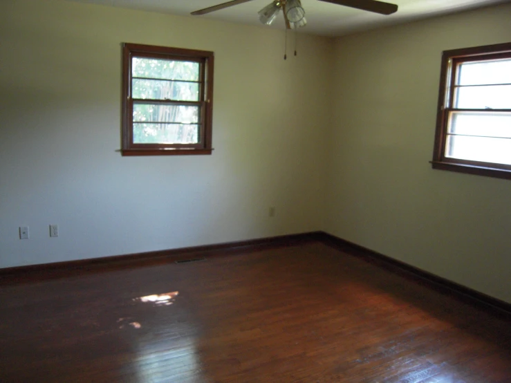 empty room with two windows and a wood floor