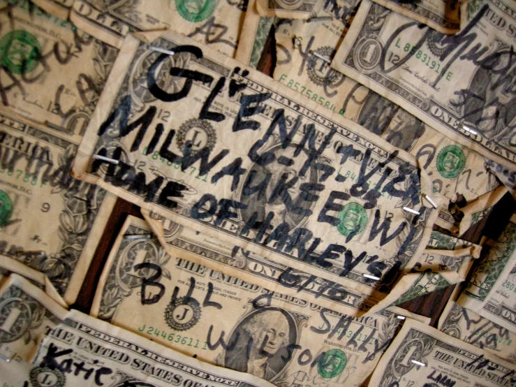 a close up of many dollar bills with writing on them