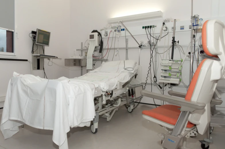 a hospital room with chairs, tables, and medical equipment