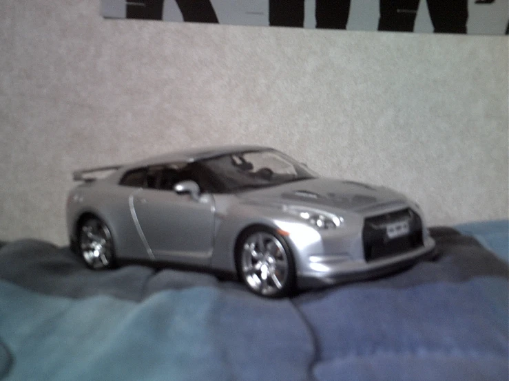 silver sports car parked on blue clothed bed