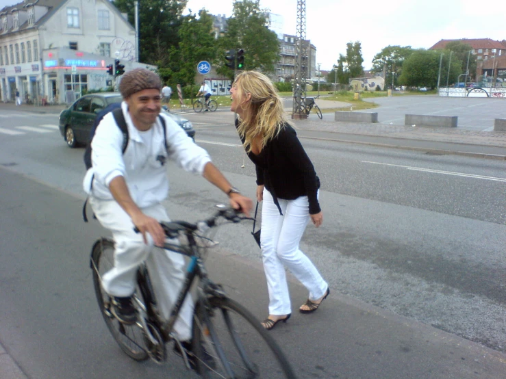 two people riding bikes down the street on both sides of the road