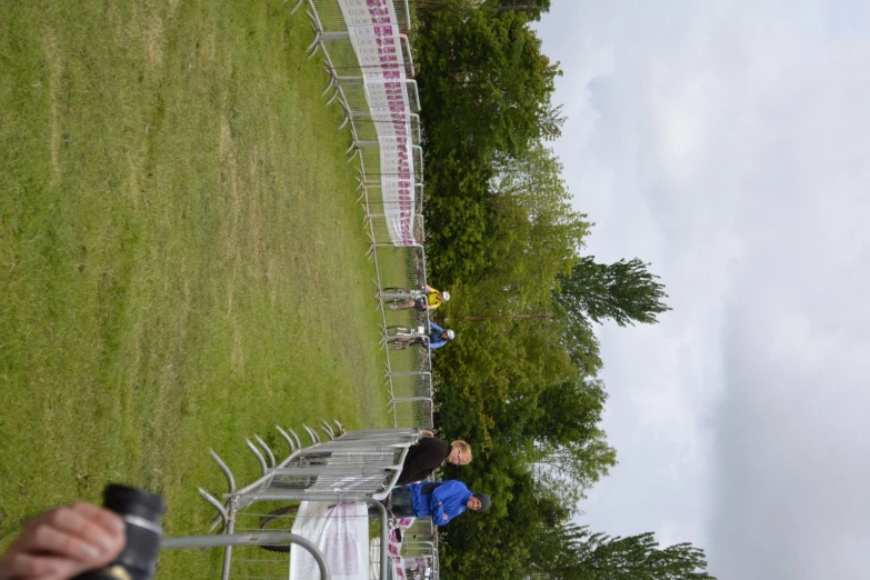 people in a field near a row of white chairs