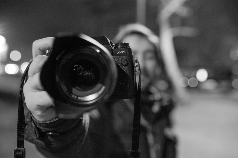 a person holding up a camera at night