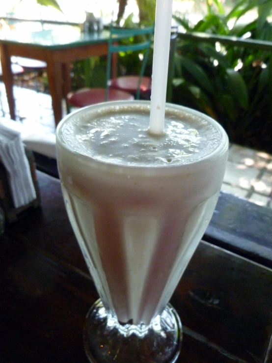 a tall drink sitting on top of a glass