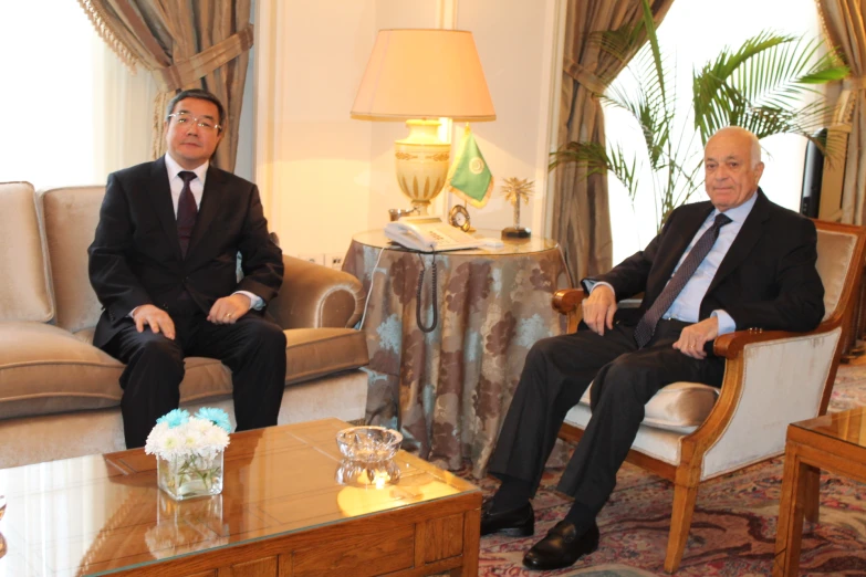 two men sitting next to each other in chairs