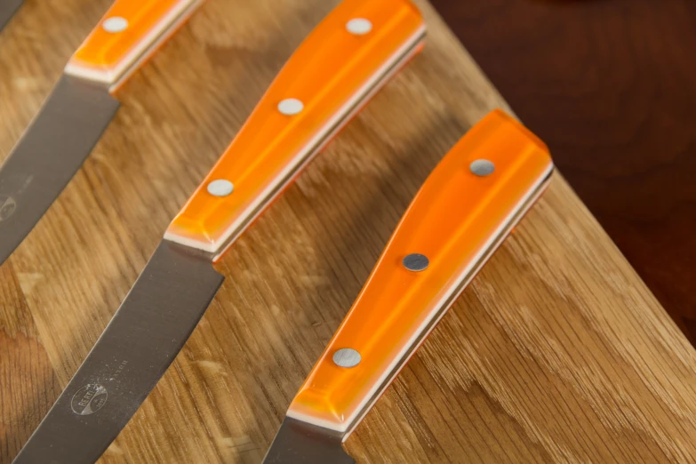 a group of knives that are sitting on top of a wooden table