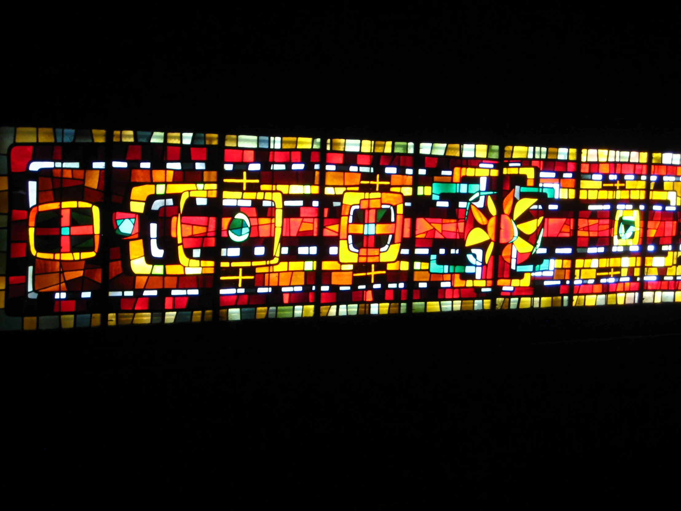 a stained glass window is bright colored and has designs