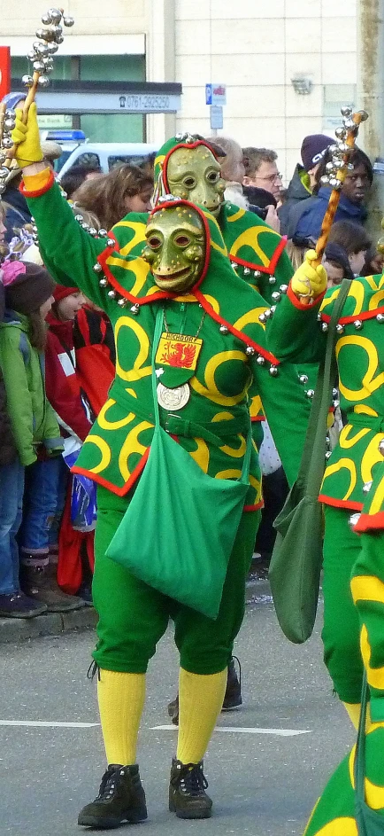 the three men are wearing green and yellow costumes