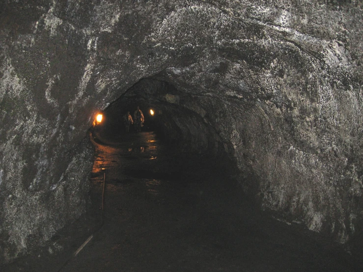 the tunnel is filled with dark rock and street lights