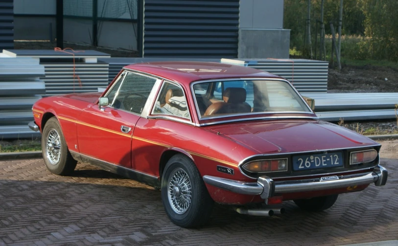 a red car parked on a brick road