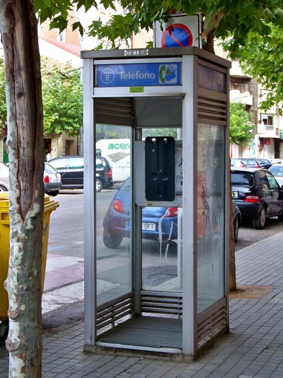 a telephone booth on a sidewalk in the middle of a city