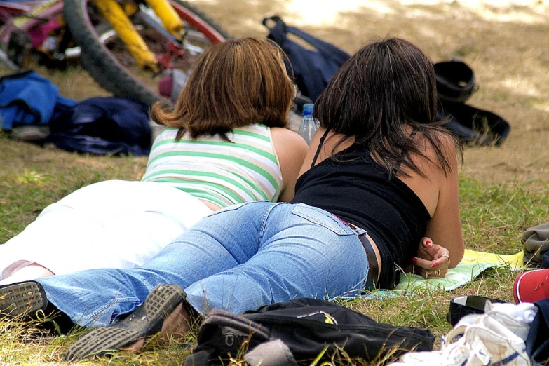 two young women sitting together on the ground