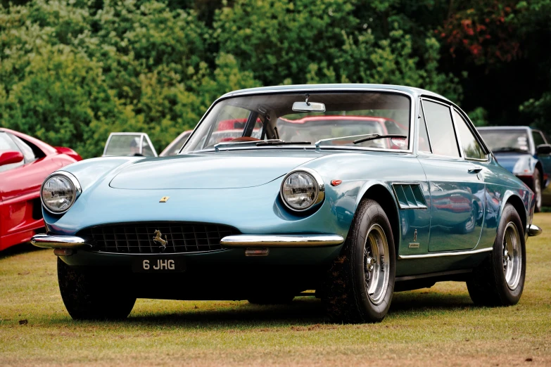 a vintage car parked in a field next to others