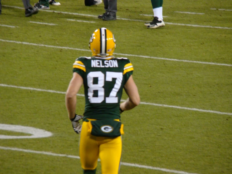 the player is in his uniform looking down at the ground