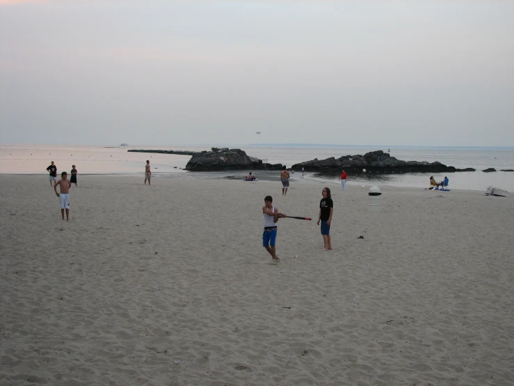 many people are at the beach playing ball