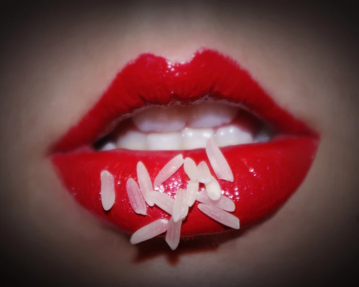 a closeup of someone's lips with white glitter and red material on the lip