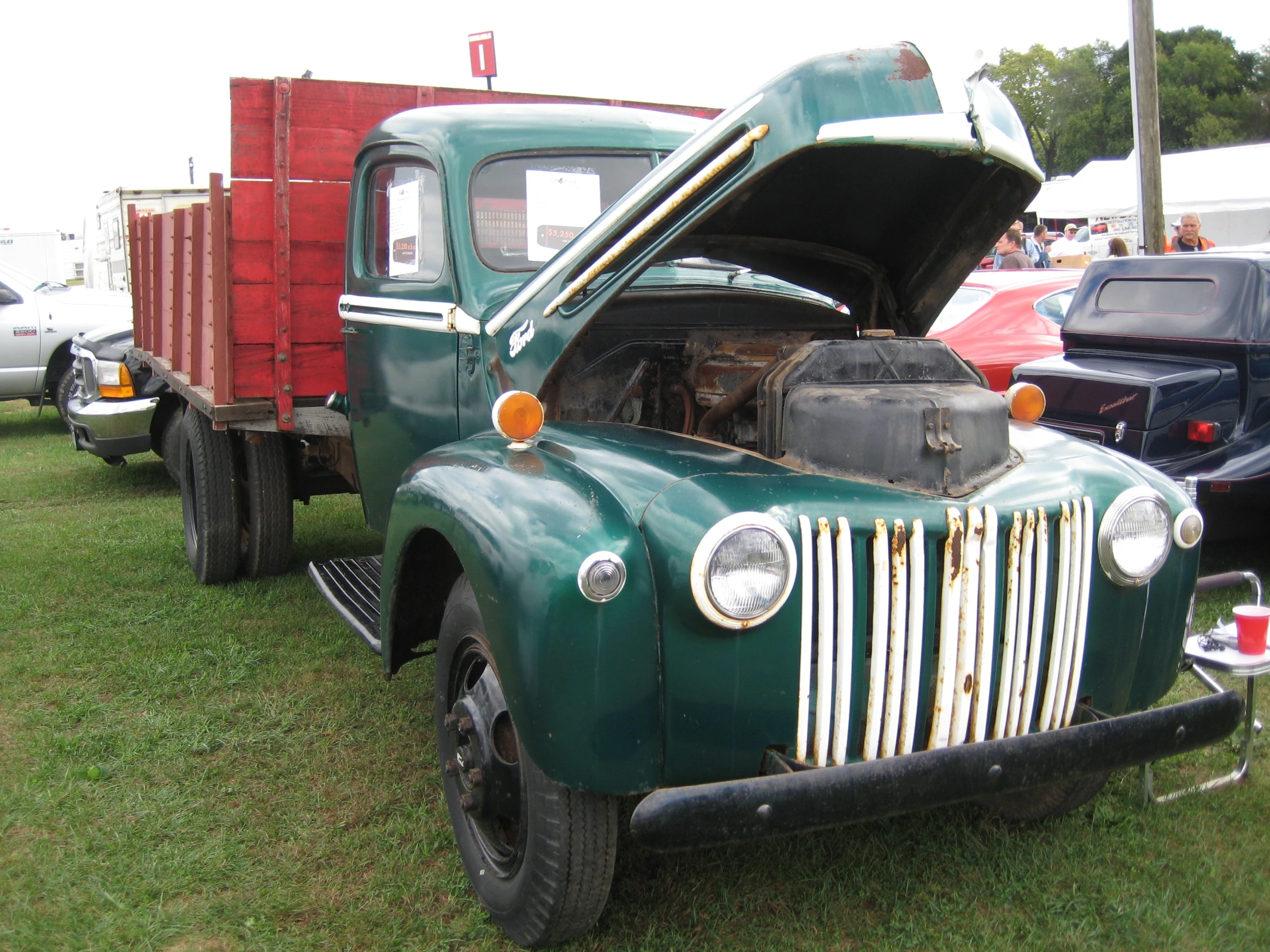 a very old style pick up truck with its hood open