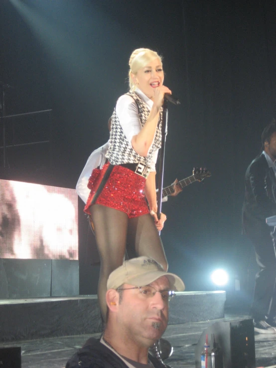 blonde lady in red skirt on stage singing