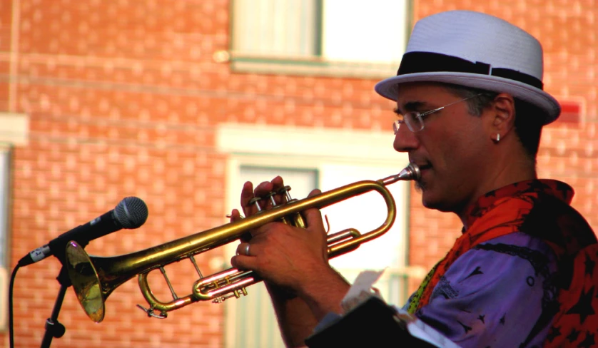 a man with a hat and glasses holding a trumpet