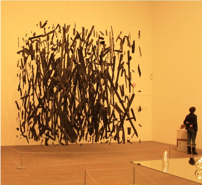 a woman standing in front of a tall sculpture of birds