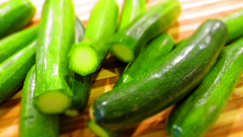 cucumbers on a table and in a pile ready to be peeled