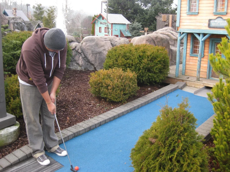 a man holding a golf club getting ready to put a putter