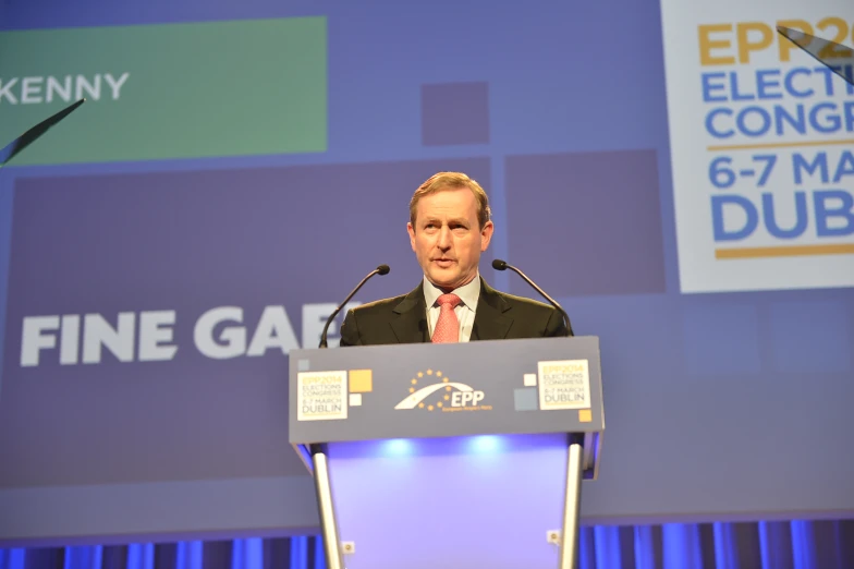 a man standing at a podium with a microphone