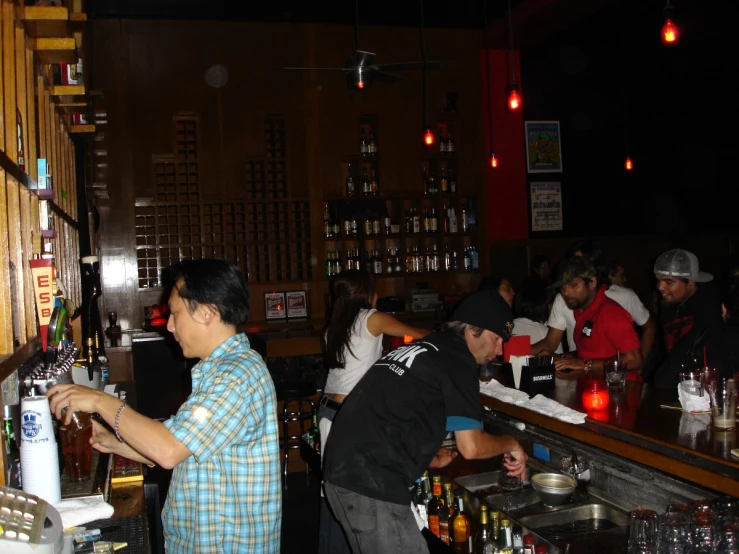 several people are lined up at the bar to have drinks