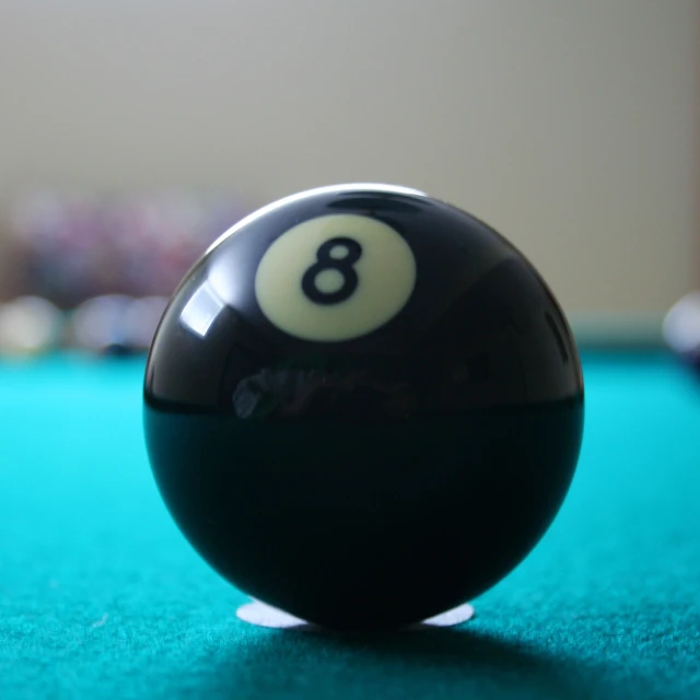 a black and white bill ball on a green cloth table