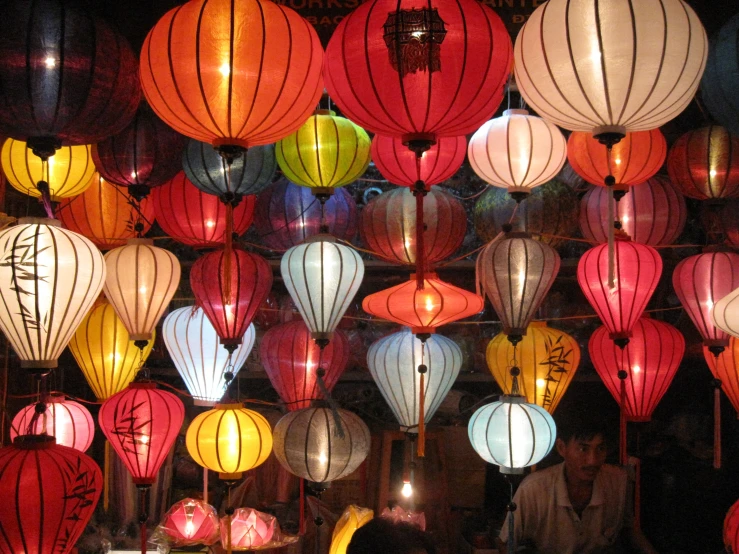 lots of lit paper lanterns on the ceiling