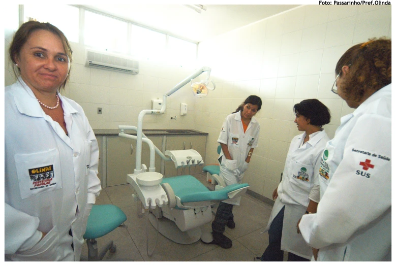 a group of people standing around an operating room