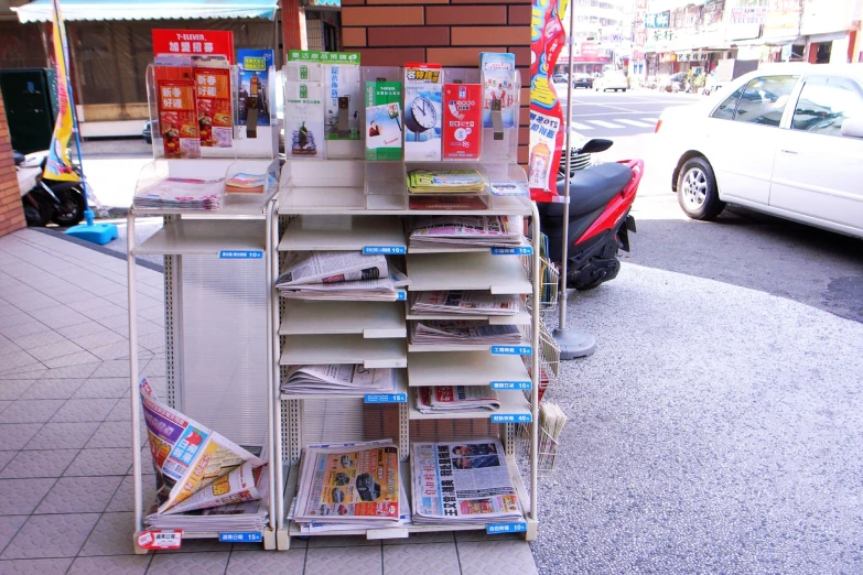 multiple stacks of newspapers are stacked up on a rack