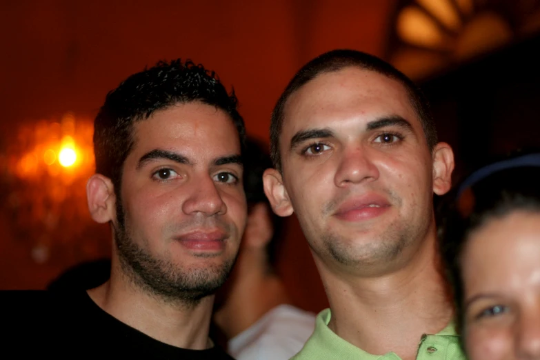 two young men stand together at a party