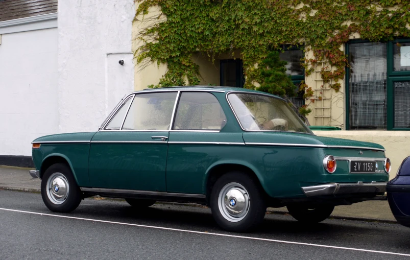 a small green car parked beside a blue car