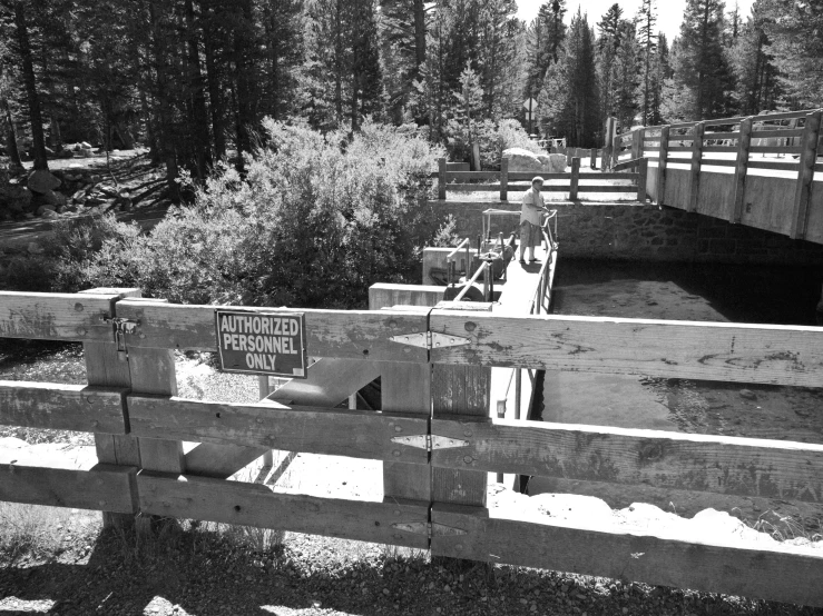 a bridge has wooden posts and a metal railing