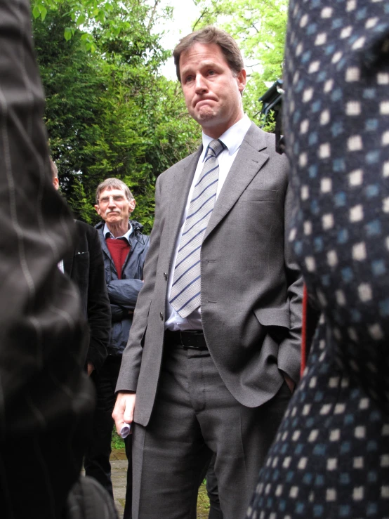 an image of a man wearing a suit at an outdoor event