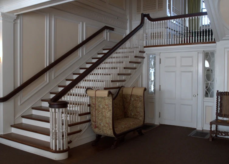 a white room with a white stairway and couches