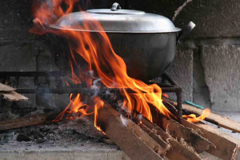 a big fire is burning in a metal pot