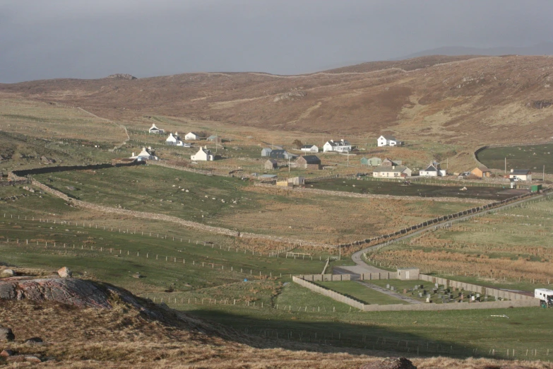 small farm houses nestled on the side of a hilly area