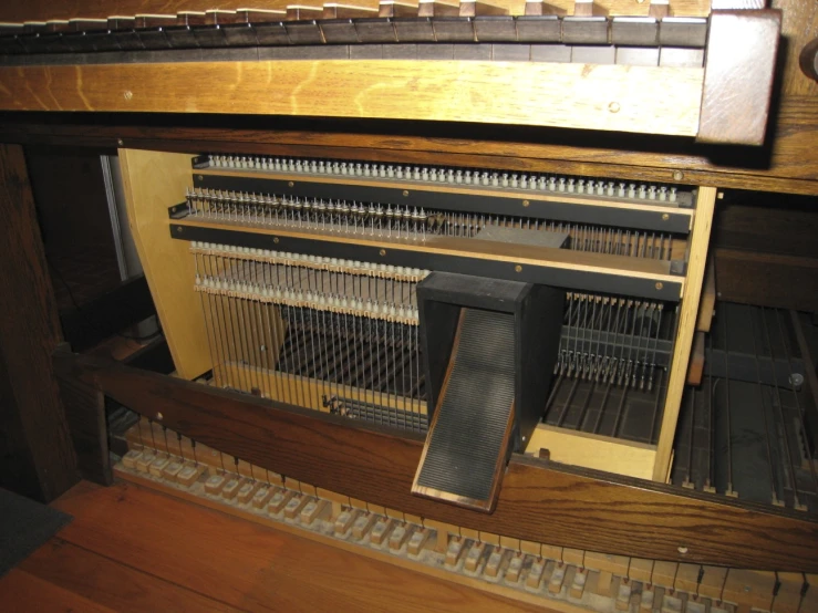 an upright piano has the keys and a side panel missing