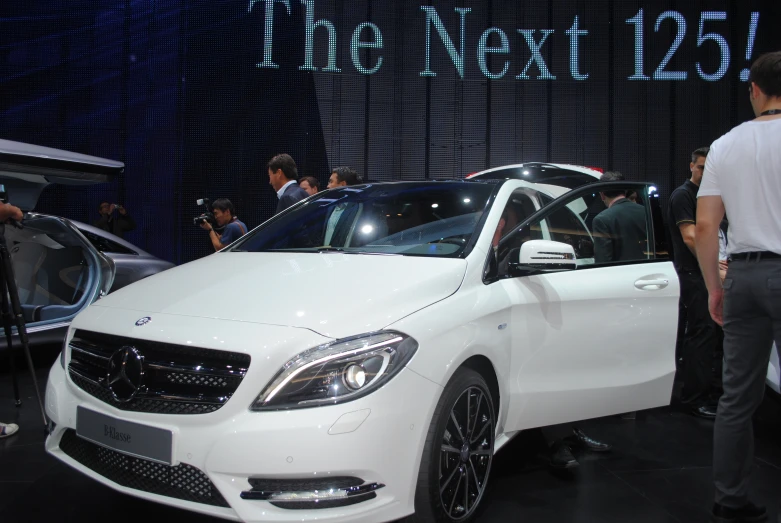 a man stands in front of a mercedes benz benz benz