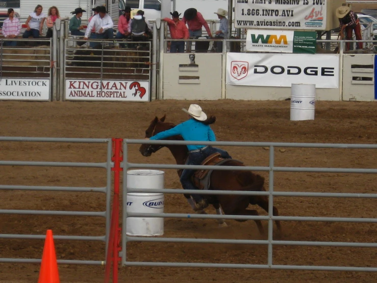 a cowgirl is riding on a bucking horse at a rodeo