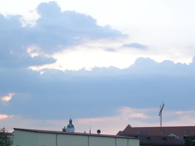 clouds loom above the buildings of a building with a clock tower