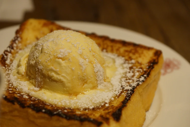 a slice of toast and ice cream on a white plate