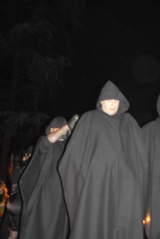 a group of people in hooded clothes standing on a street